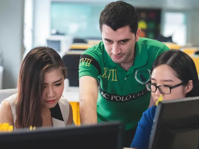 Team collaborating at desktop computers in a bright office, City Service Lookup supports businesses listing